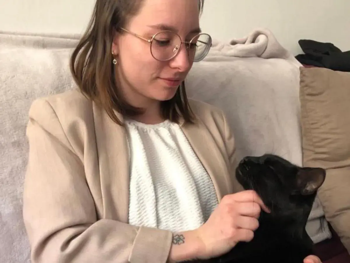 une femme comportementaliste avec un chat noir sur les genoux